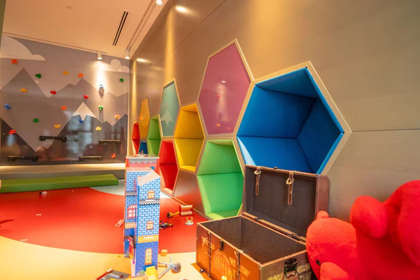 Un espace de jeux avec des structures hexagonales aux couleurs vives et un petit bâtiment bleu.