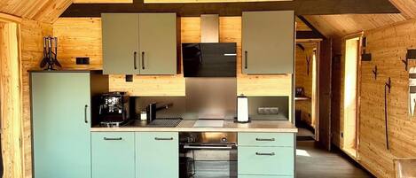 A compact kitchen with a ceiling fan, a dining area with a table and chairs, and a cozy seating area with a sofa.