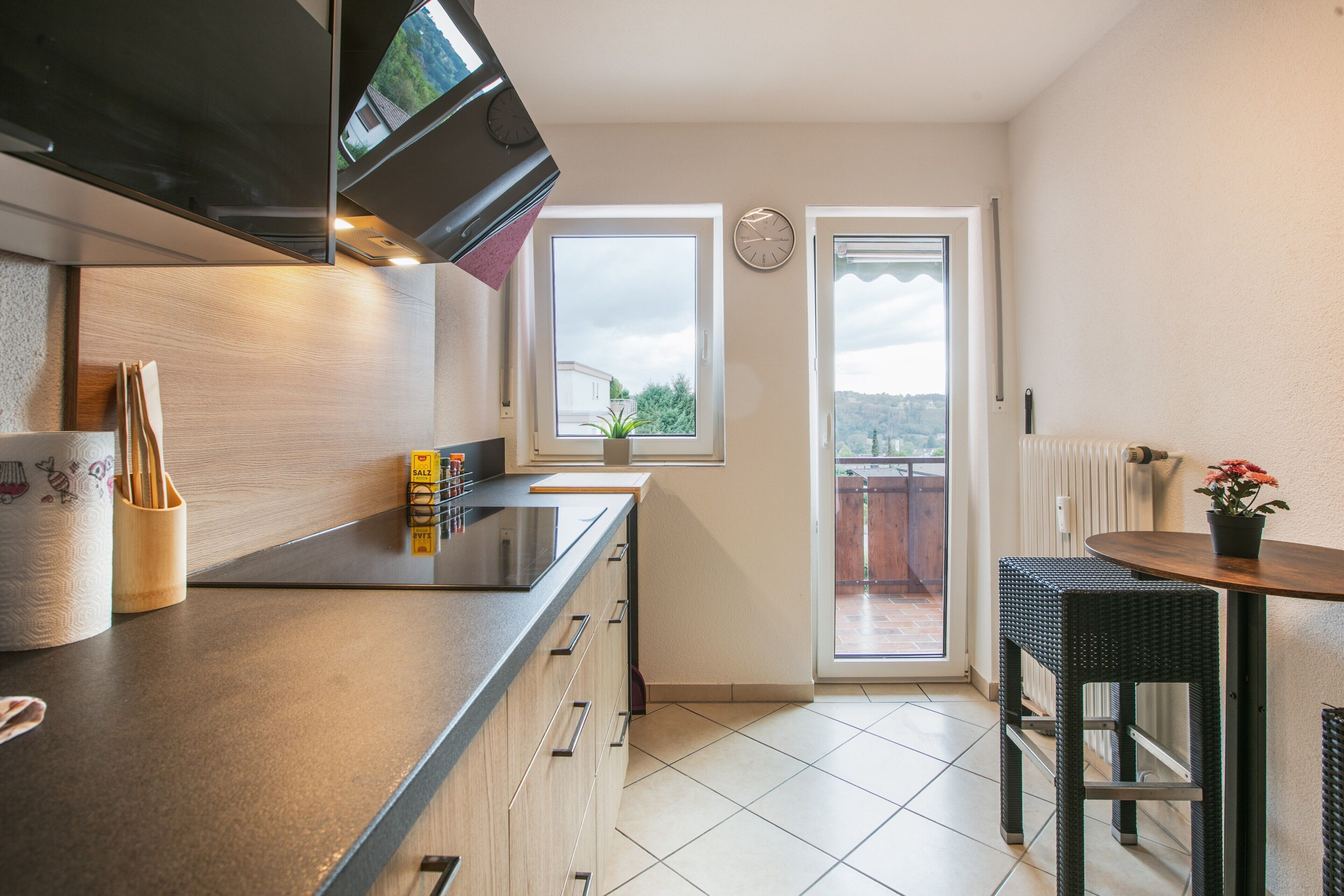Una cucina moderna con forno integrato, una finestra vista e un'area pranzo con tavolo e sedie.
