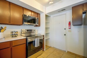 A kitchen with a microwave, oven, and cabinets. - The Airman House: Pool/Hot Tub Fun By Lackland AFB (San Antonio)