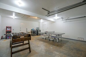 A room with a foosball table, a ping pong table, and a kitchenette area. - The Airman House: Pool/Hot Tub Fun By Lackland AFB (San Antonio)