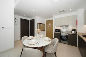 A modern kitchen with a gas stove, oven, and microwave. - Bloomfields 1BR in Creekside 18 (Dubai)