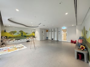 A children's playroom with a mural, storage cabinets, and a play area. - Bloomfields 1BR in Creekside 18 (Dubai)