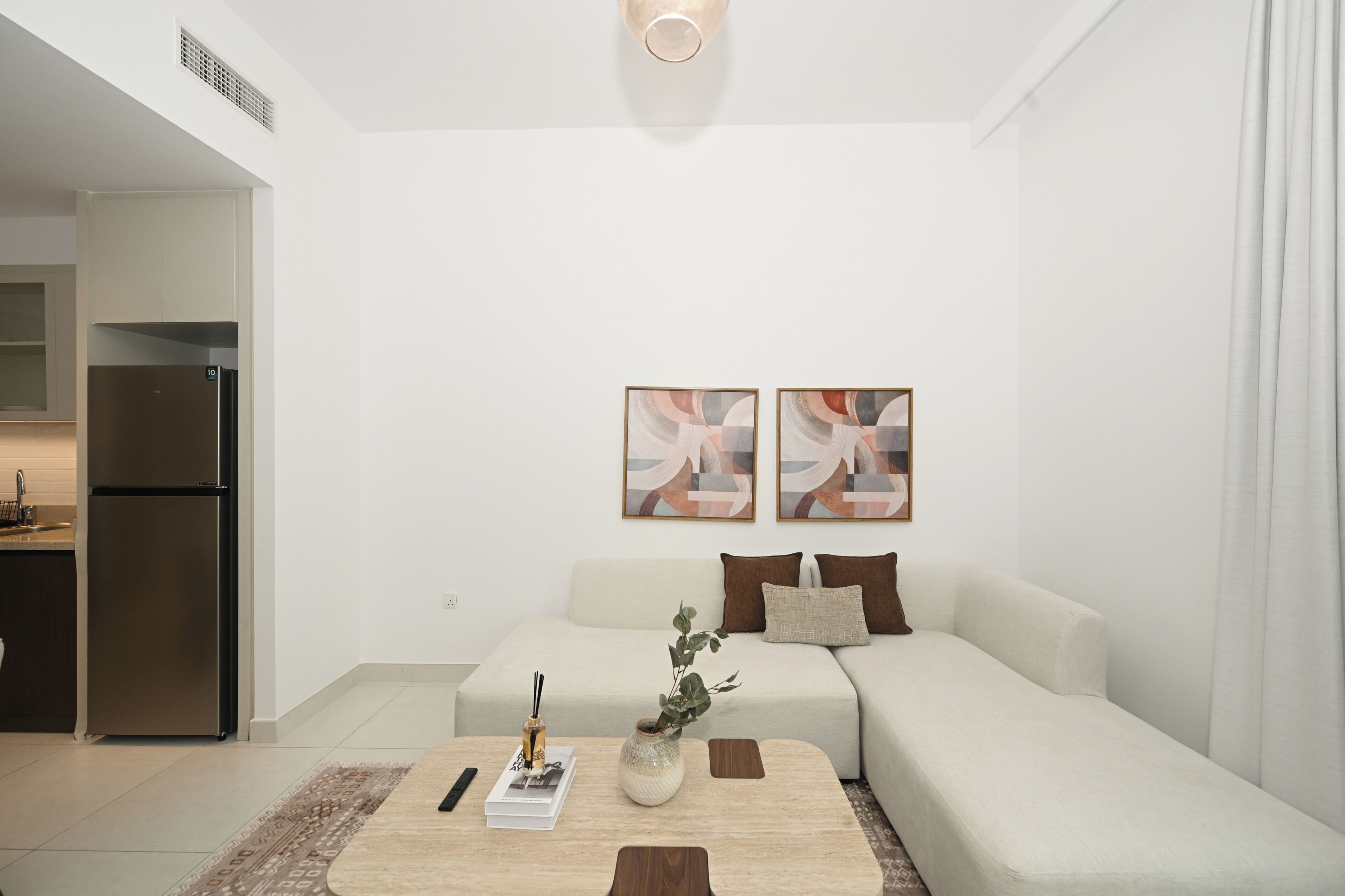 Un salon moderne avec un canapé, une table basse et des œuvres d’art accrochées au mur.