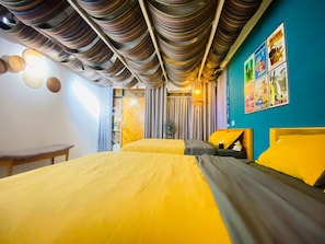 A hotel room with a bed, a desk, and a wall with pictures. - 3BR Old Quarter Stay | Walk to Lake & Beer Street | Rooftop & Soaking Tub (Hà Nội)