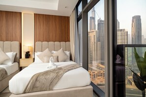 Habitació d'hotel moderna amb un llit gran, dues zones d'estar i vista a la ciutat.