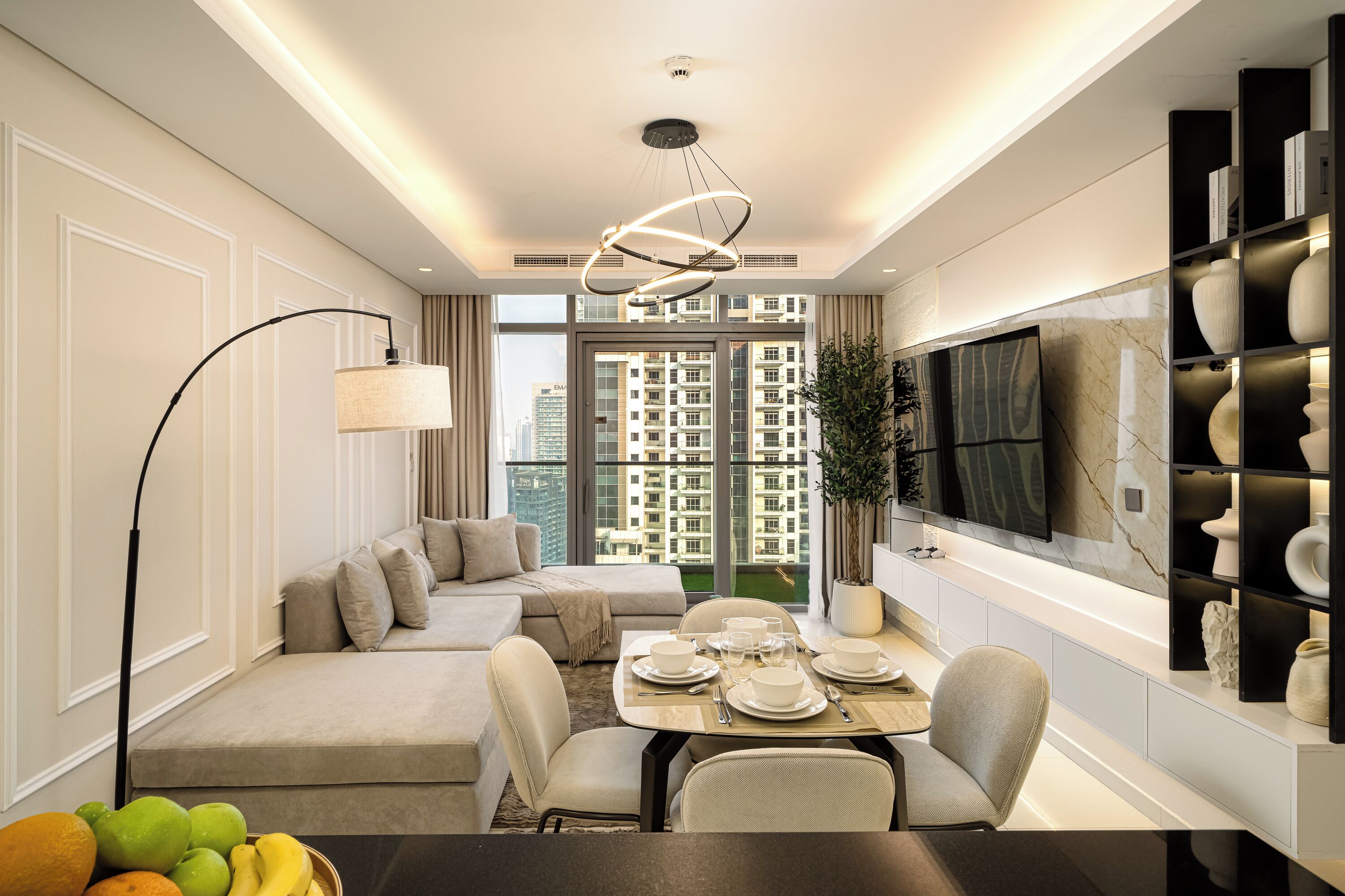 Una sala moderna con sofá, mesa de comedor y televisor grande.