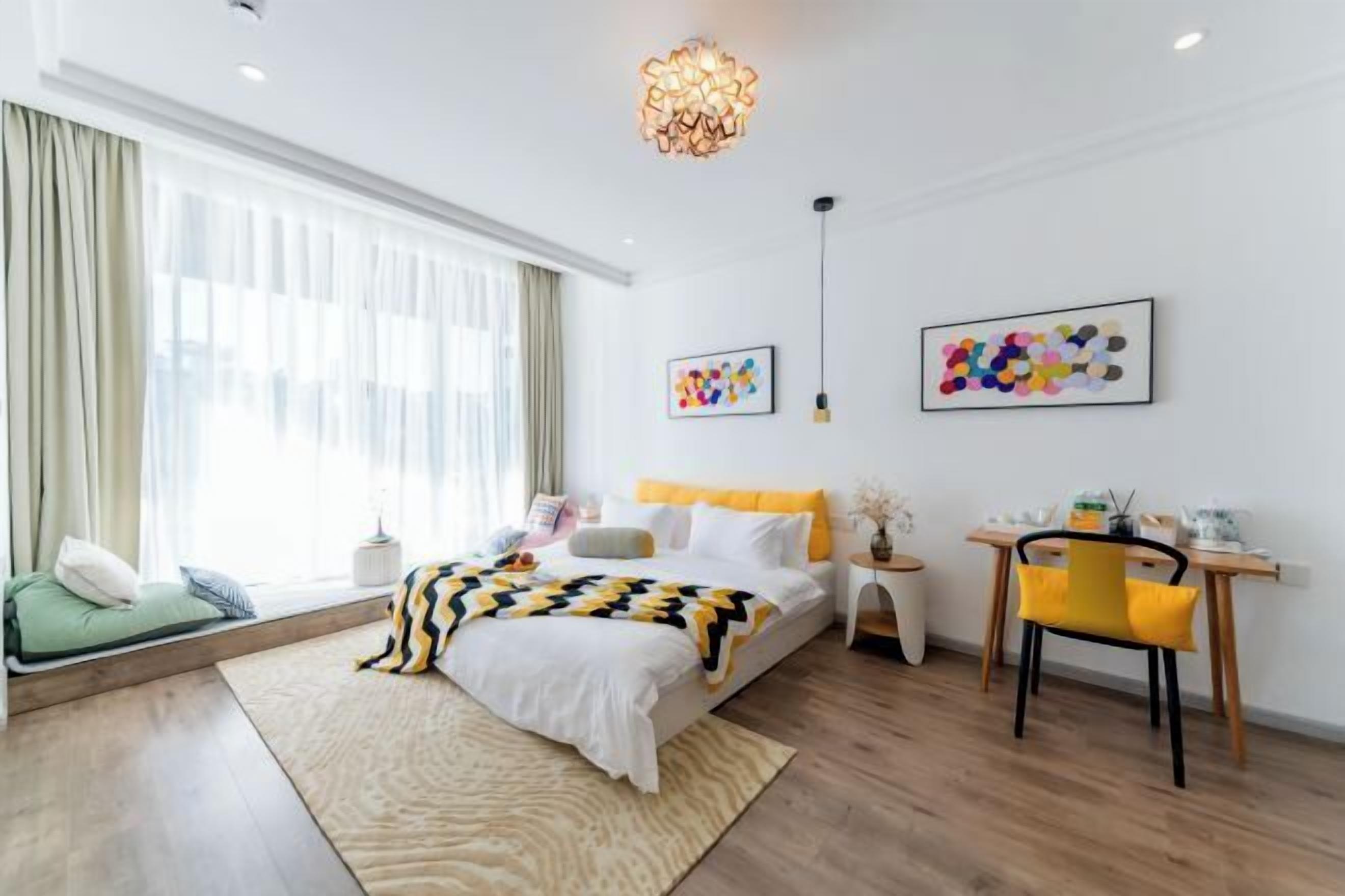 Habitación de hotel moderna con una cama grande, un escritorio y vistas a la ciudad.