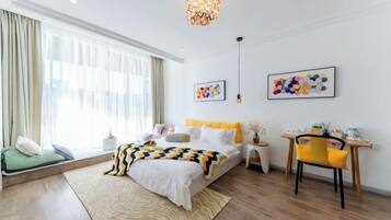 Habitación de hotel moderna con una cama grande, un escritorio y vistas a la ciudad.