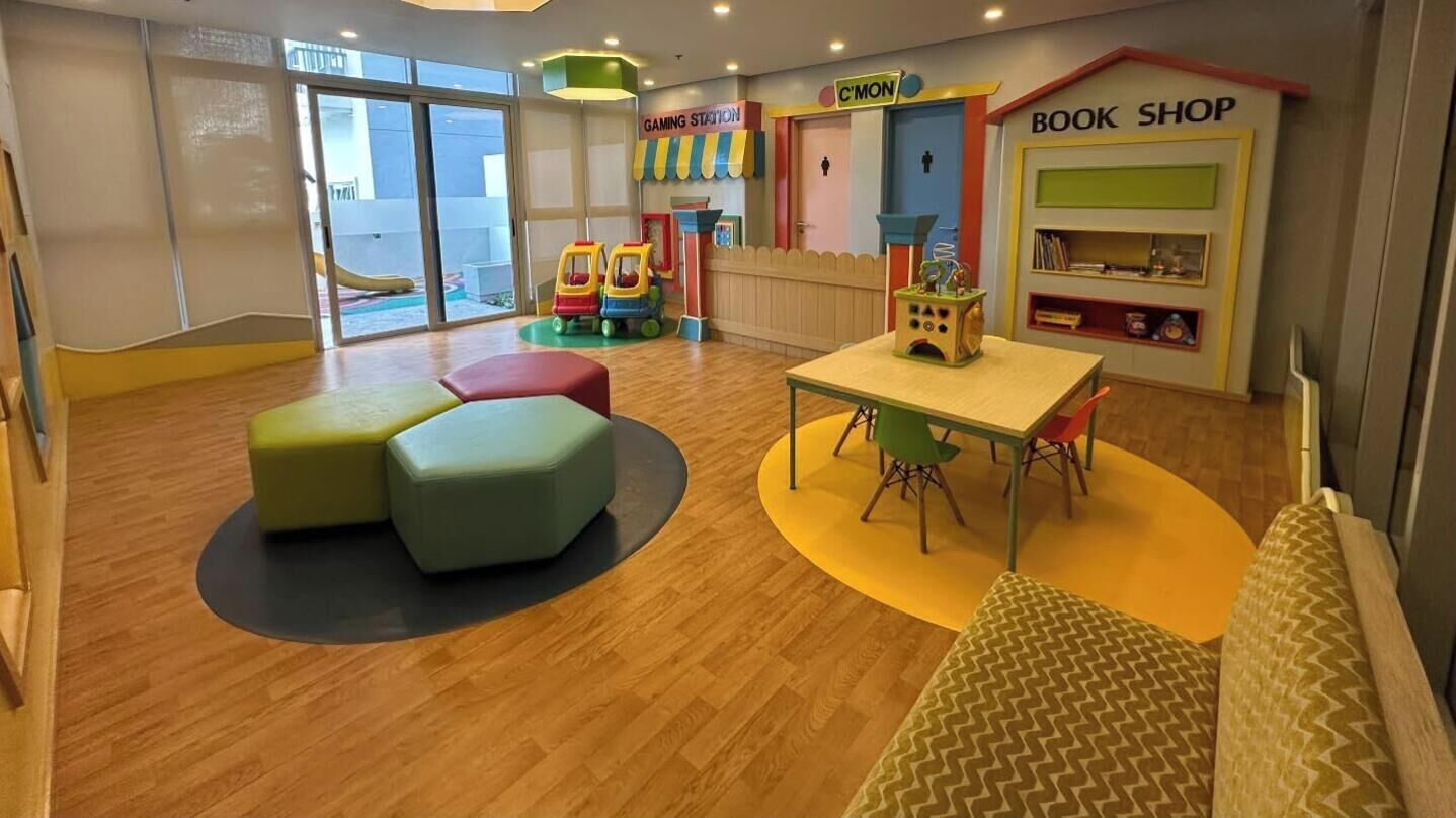 A children's play area with a table, chairs, and colorful play structures.