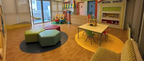 A children's play area with a table, chairs, and colorful play structures.