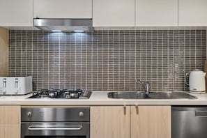 A kitchen with a gas stove, a sink, and a toaster. - Heritage Loft | Degraves Lane Melbourne CBD (Melbourne)