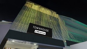 Ein Gebäude mit einem Schild, auf dem 'TOWNHOUSE' und 'OYO-Serviced' steht.
