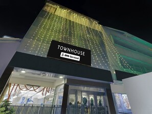 Ein Gebäude mit einem Schild, auf dem 'TOWNHOUSE' und 'OYO-Serviced' steht.