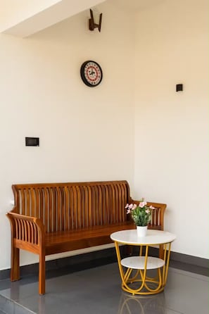 Eine hölzerne Bank mit einem runden Tisch und einem Blumentopf davor.