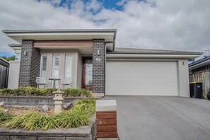 A modern two-story house with a garage, a stone pathway leading to the entrance, and a small garden with a stone lantern. - Murcott Parkside Retreat - Caddens (Caddens)