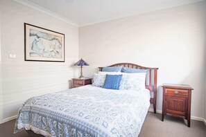 A bedroom with a bed, a nightstand, a lamp, and a wall-mounted painting. - Murcott Parkside Retreat - Caddens (Caddens)