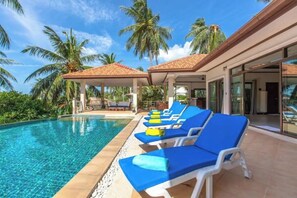 A swimming pool with lounge chairs, palm trees, and a covered area. - Family 3 bedrooms villa with sea view (Koh Samui)