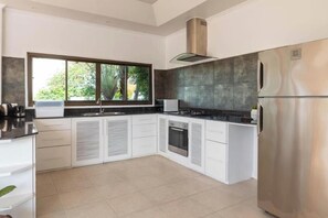Eine moderne Küche mit einem großen Fenster, Einbaugeräten und einem Edelstahl-Kühlschrank.