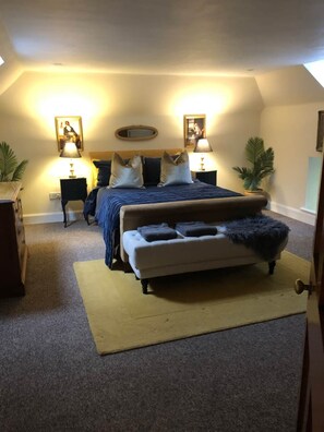 A bedroom with a bed, bedside tables, lamps, and a small sofa. - Pet-Friendly Woodland Escape, 30 acres, Turriff. (Turriff)
