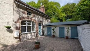 A building with a gravel courtyard, a large arched window, and a door. - Pet-Friendly Woodland Escape, 30 acres, Turriff. (Turriff)