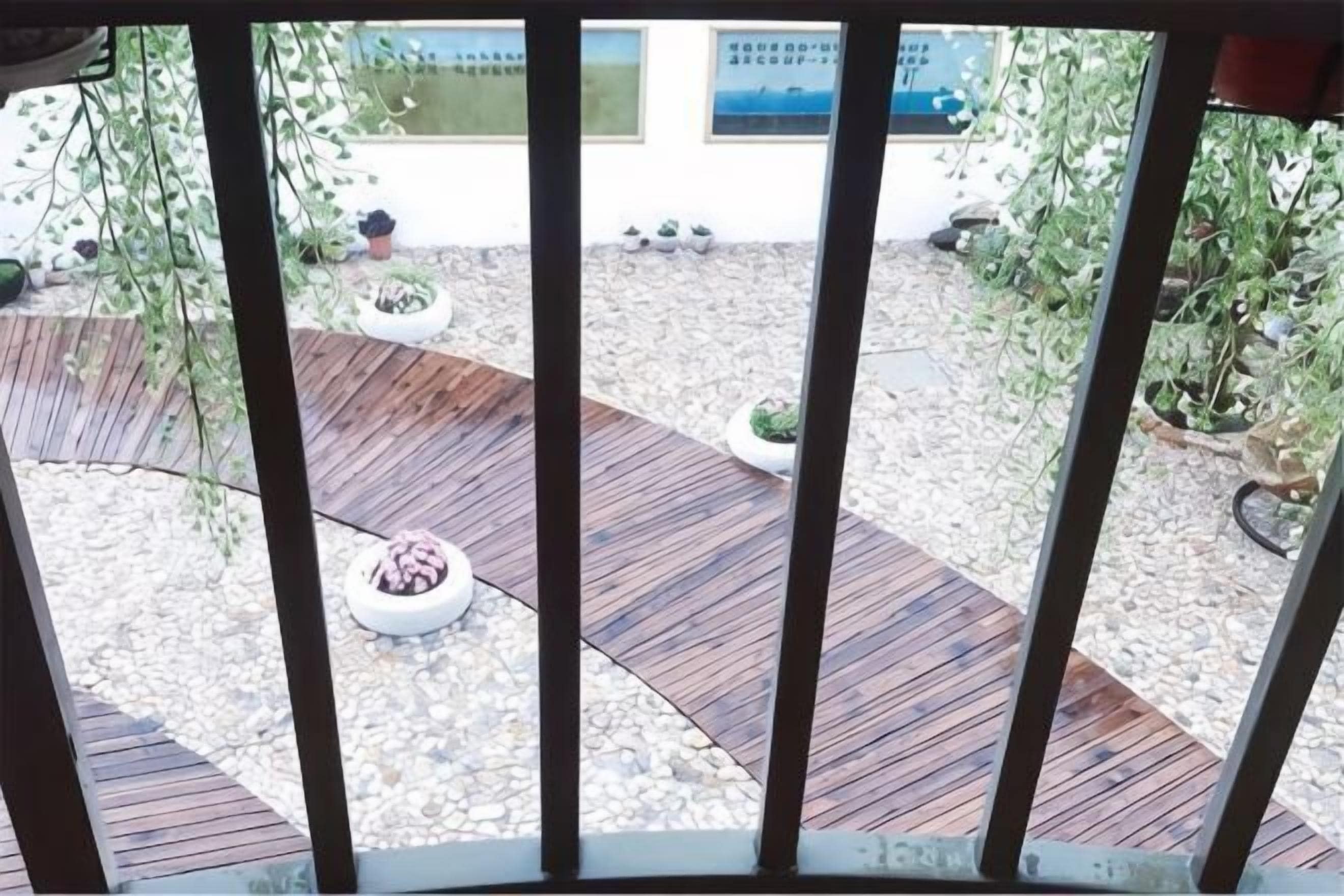 A wooden deck with planters and a gravel area.