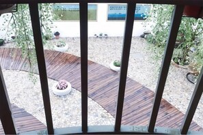 A wooden deck with planters and a gravel area.