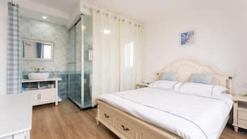 Un dormitorio con cama, mesita de noche y baño con ducha.