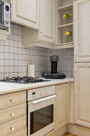 A kitchen with a gas stove, a coffee maker, and a microwave. - Luxury Marylebone Flat | 2 Bed 2 Bath (Greater London)