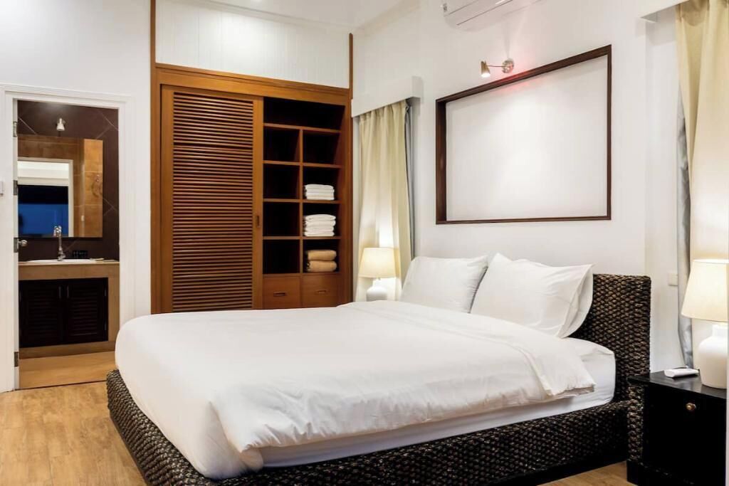 Ein Hotelzimmer mit einem großen Bett, einem Schrank mit Schiebetüren, einem Nachttisch mit Lampe und einem gerahmten Bild an der Wand.