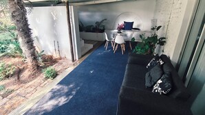 A covered outdoor seating area with a blue carpet, white walls, and a white ceiling. - Lemon & Co (Bela-Bela)