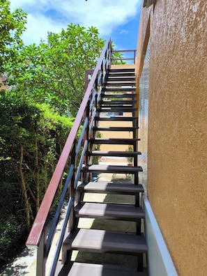 Uma escadaria com grades de metal que leva a um edifício.