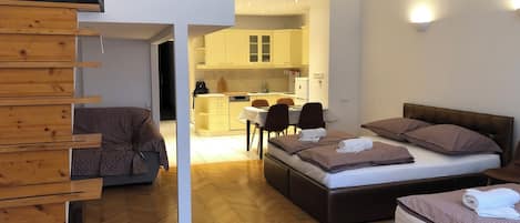 A modern bedroom with a bed, a sofa, and a wooden storage unit.