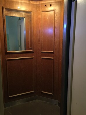 A wooden elevator door with a mirror and a small light fixture above it. - Fabulous 1-bedroom studio with AC in vibrant Budapest (Budapest)