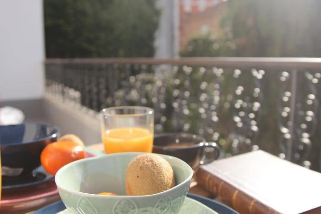 A table with a bowl of food, a glass of orange juice, and a book.