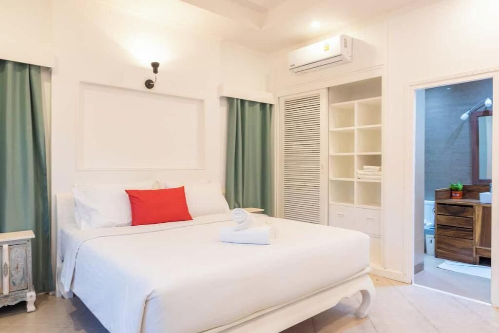 Ein Hotelzimmer mit einem Bett, einem Kleiderschrank und einem durch eine offene Tür einsehbaren Badezimmer.