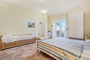 A bedroom with two beds, a television, and a wardrobe. - [StairwayToHeaven Room 2] 5Terre-Seaview (Riomaggiore)