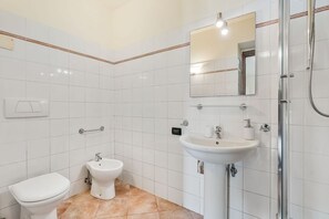 A bathroom with a toilet, bidet, sink, and a shower stall. - [StairwayToHeaven Room 2] 5Terre-Seaview (Riomaggiore)