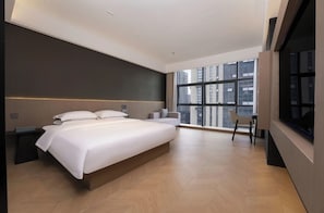 Un dormitorio moderno con una cama grande, un escritorio y una silla.