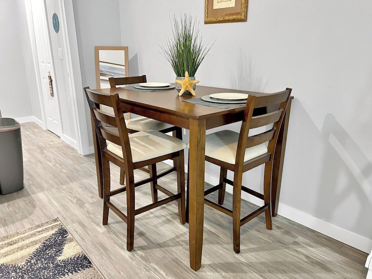 A dining table with four chairs, a potted plant, and a starfish decoration.