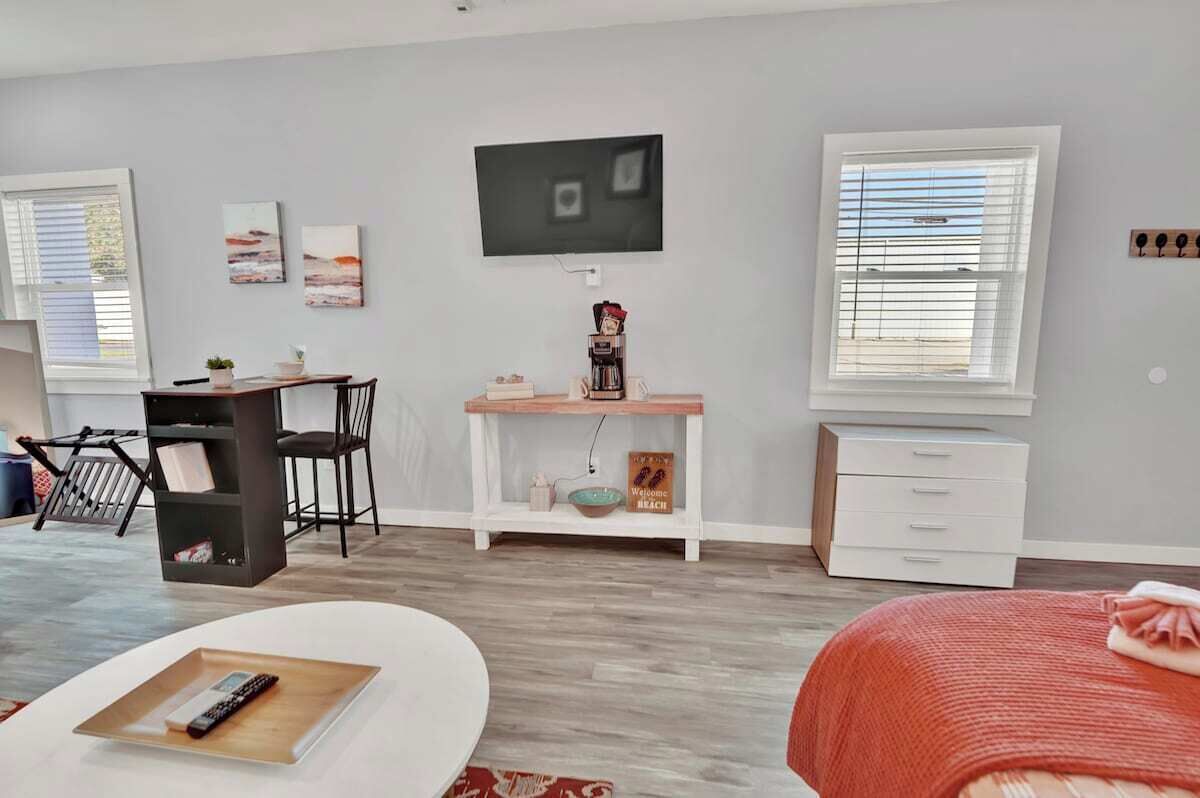 A modern living room with a flat-screen TV, a coffee machine, and a bookshelf.