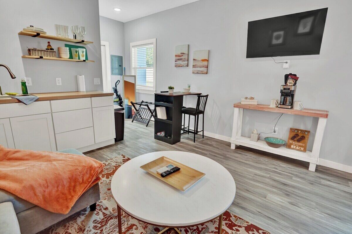 A modern living room with a sofa, coffee table, and a flat-screen TV mounted on the wall.