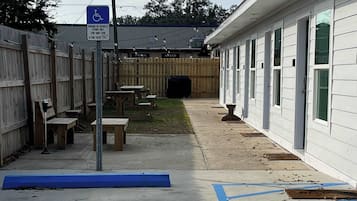 A building with a wheelchair-accessible parking area marked by blue lines and a sign.
