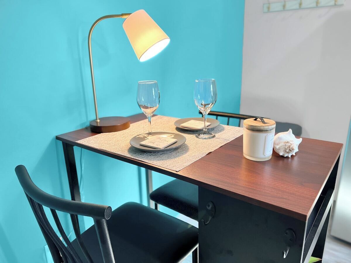 Een eettafel met twee borden, twee wijnglazen, een kaars en een schelp.