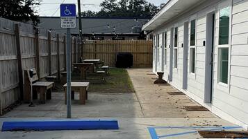 A building with a wheelchair-accessible parking area marked by blue lines and a sign.