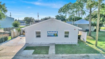A small, single-story building with a sign that reads 'SEASIDE Escape' and a palm tree graphic.