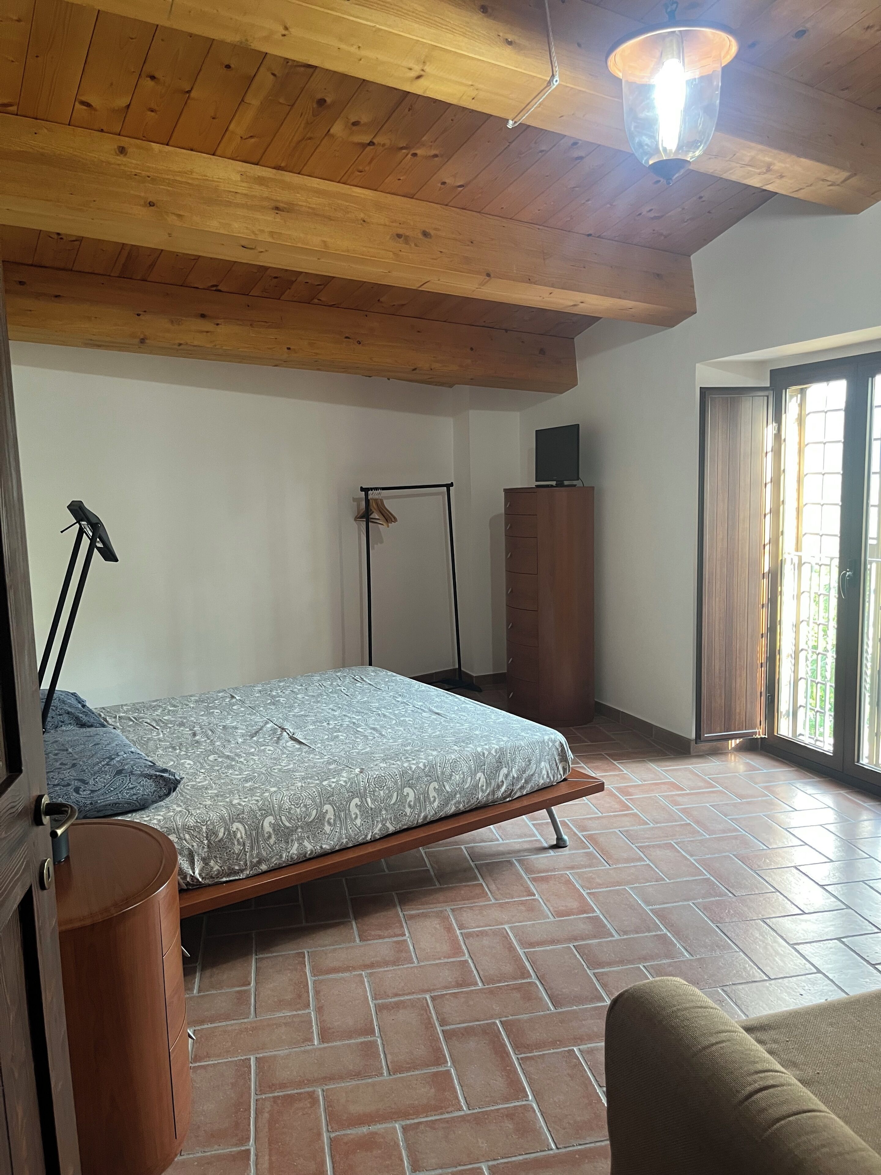 Una camera da letto con un letto, un armadio, una scrivania e una sedia.