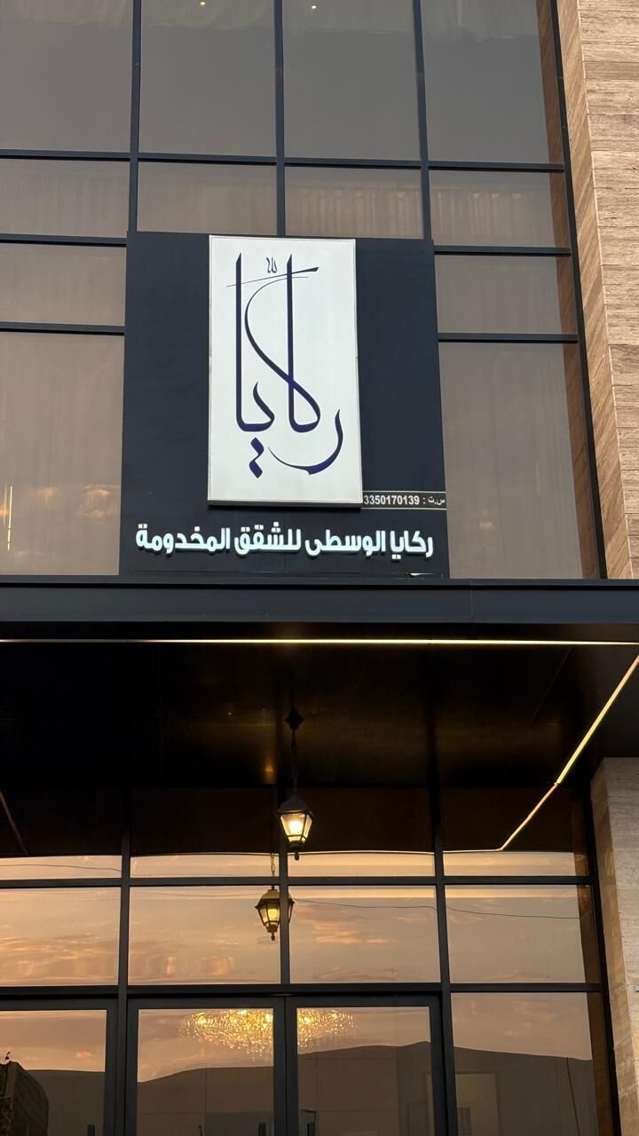 En bygnings facade med et stort vindue og et skilt med arabisk skrift.