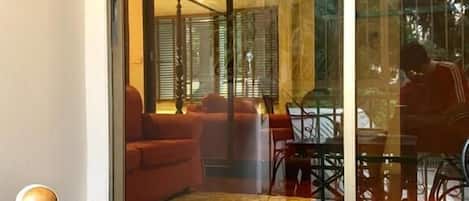 A glass window with a view of an indoor seating area, a cigar in a glass ashtray, and a magazine titled 'Bangkok Then & Now'.