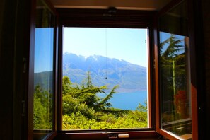 A window with a view of a mountain range and a lake. - Arias Giovanna Visa Lago Villa (Tremosine)
